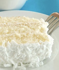 a slice of coconut cake on a plate with a fork