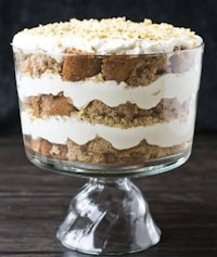 a trifle in a glass bowl with whipped cream on top