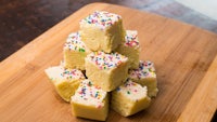 a stack of squares of fudge with sprinkles on top