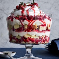 a trifle with strawberries and cream in a glass bowl